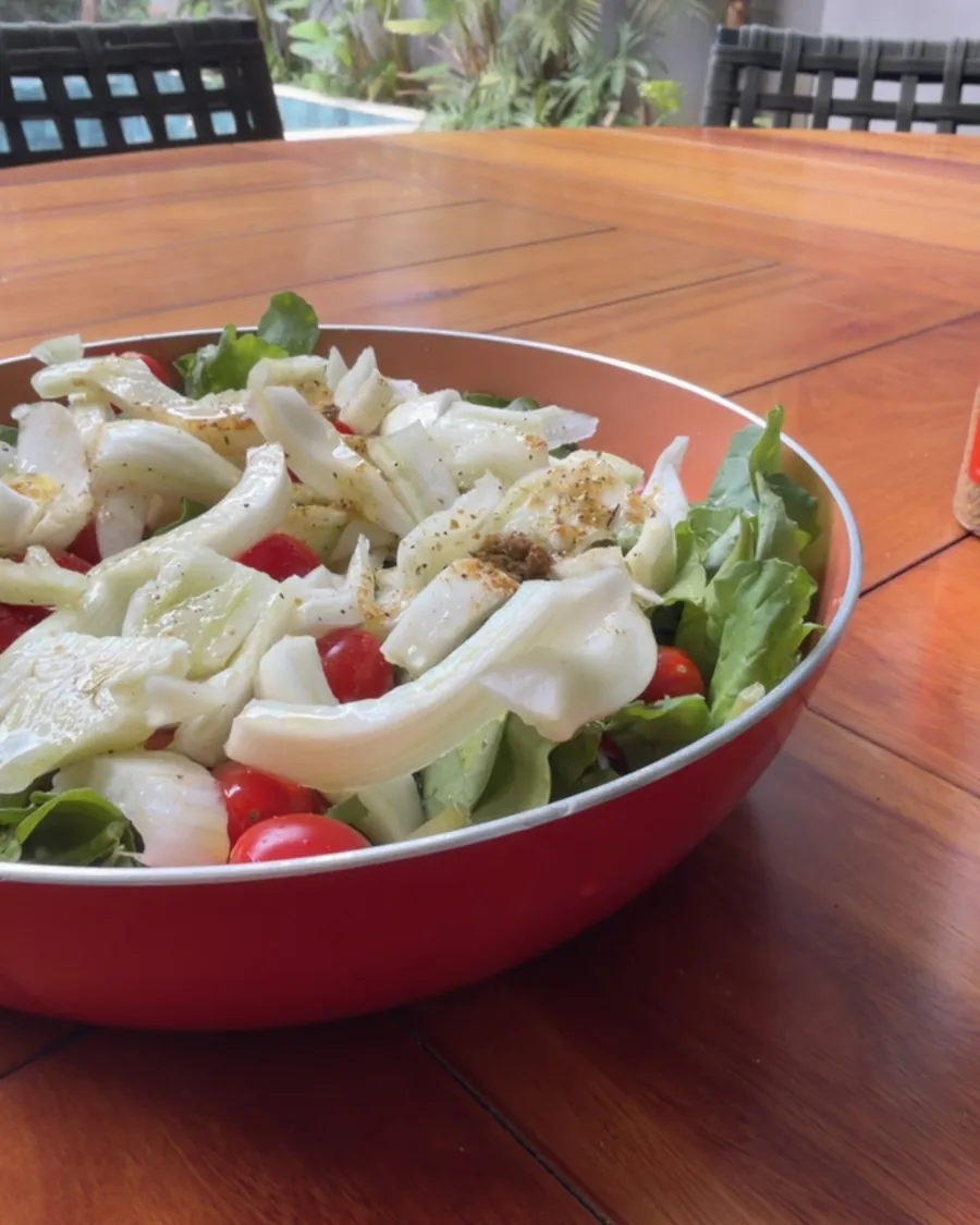 Salada de funcho, tomate e folhas em uma tigela vermelha